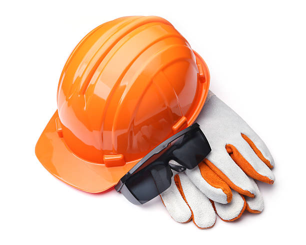 orange hard hat and leather gloves on a white background